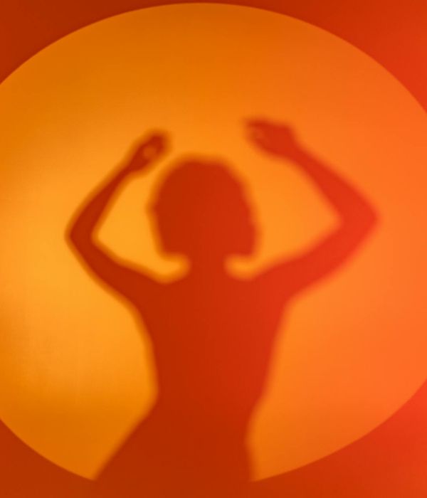 Woman performing a graceful cardio movement in a bright studio.